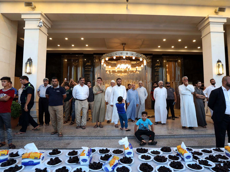 عدد من النازحين ينتظرون مدفع الإفطار خلال إفطار جماعي أقيم بالمسجد الكبير في أربيل مساء أمس الأول     (أ ف ب)