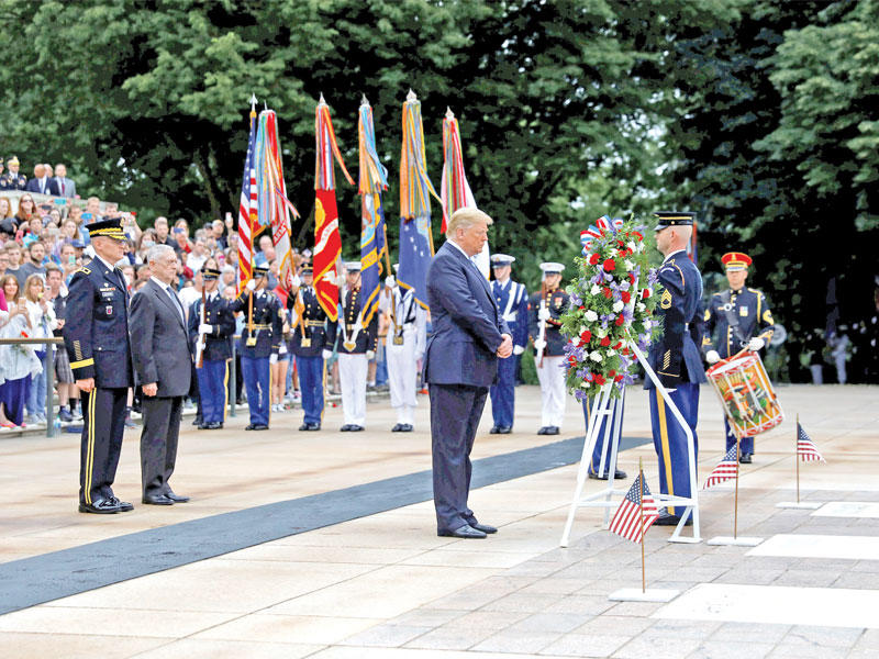 ترامب يحضر مراسم وضع الزهور على قبر الجندي المجهول في مقبرة أرلينغتون أمس الأول (رويترز)