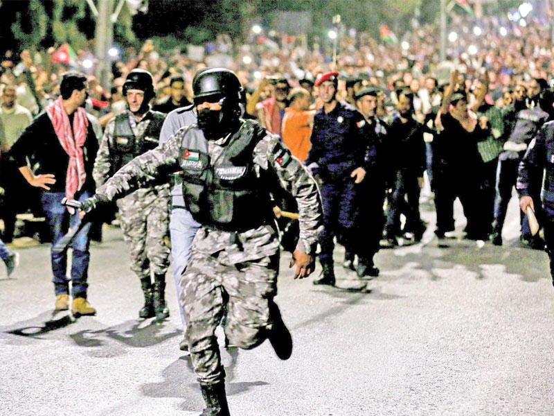 قوات الأمن تحاول منع المحتجين فجر أمس من الوصول إلى مكتب رئاسة الحكومة في عمان (ا ف ب)