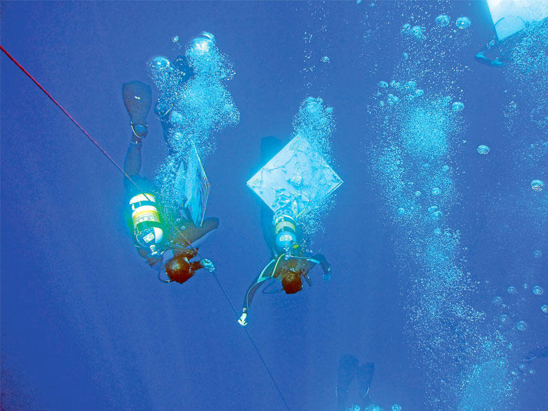 غطاسان لبنانيان من اصل 45 غطاساً شاركوا في وضع 150 لوحة لـ 85 فناناً لبنانياً تحت مياه البحر في محاولة لكسر الرقم القياسي في غينيس للوحات تحت الماء       (أ ف ب) 