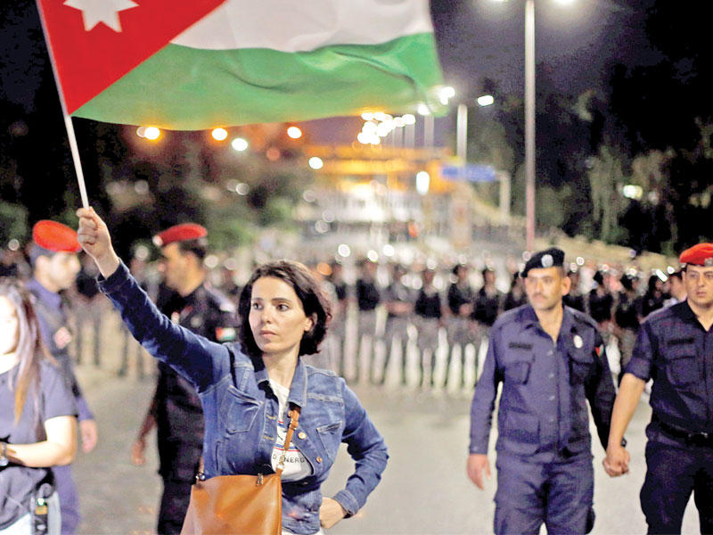 أردنية تحمل علم بلادها في عمان أمس الأول (رويترز)