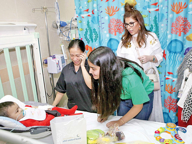 أعضاء «لوياك» و«الأهلي المتحد» خلال زيارة أحد الأطفال