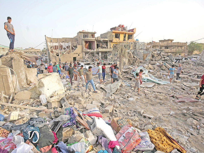 عراقيون يتفقدون مكان الانفجار في منازلهم بمدينة الصدر أمس الأول (أ ف ب)