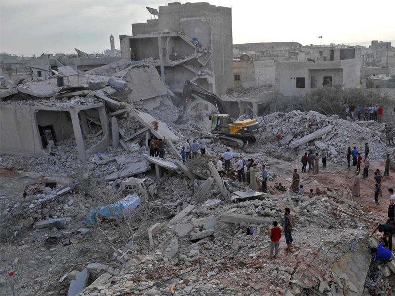 سوريون يبحثون عن ناجين تحت الأنقاض في زردنا بإدلب أمس (أ ف ب)