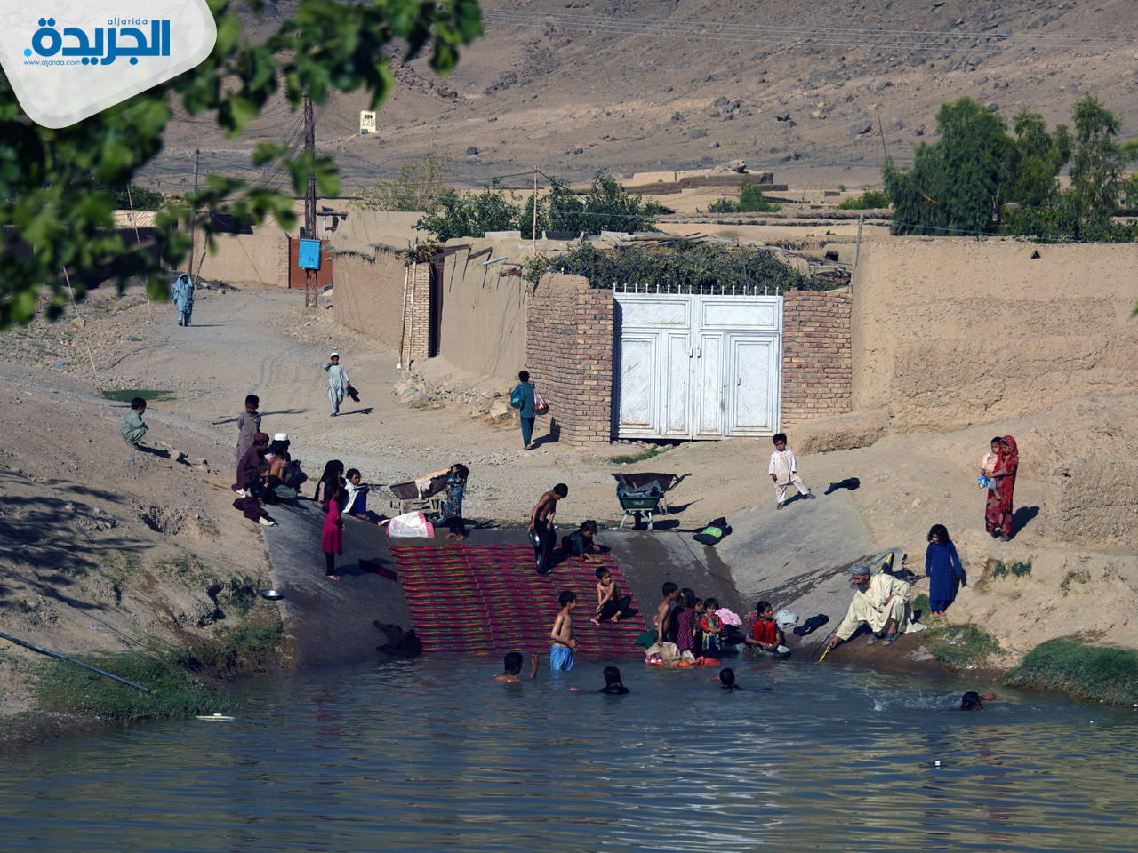 أطفال يلهون في بحيرة مائية لتخفيف درجة حرارة الجو