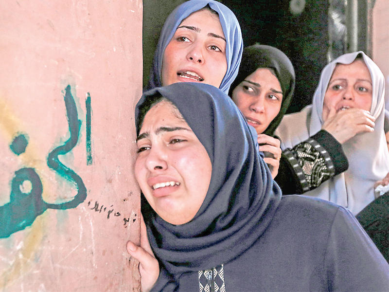 فلسطينيات يندبن خلال تشييع أحد القتلى الفلسطينيين في غزة أمسt(أ ف ب)