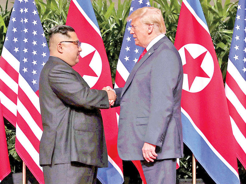 المصافحة التاريخية بين ترامب وكيم قبيل قمتهما في سنغافورة أمس (رويترز)