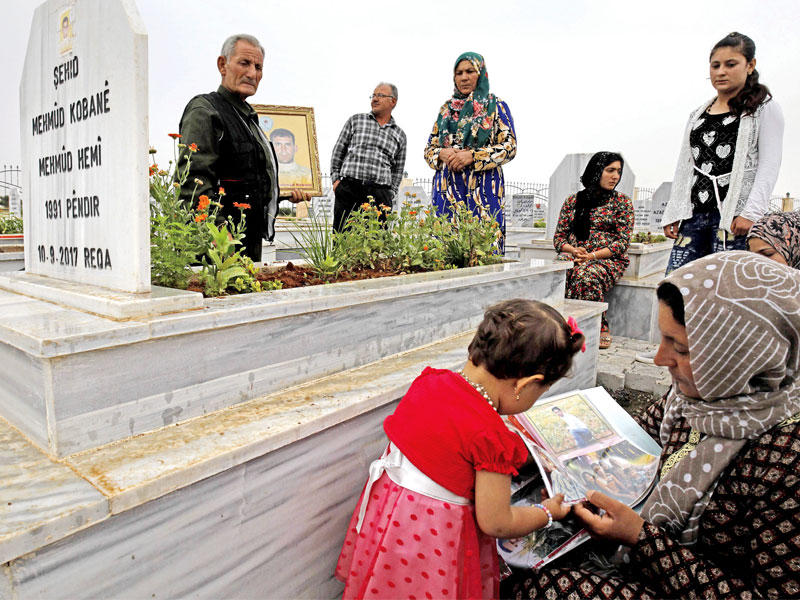 أكراد يزورون قبور ذويهم في مقبرة كوباني في 28 مايو (أ ف ب) 