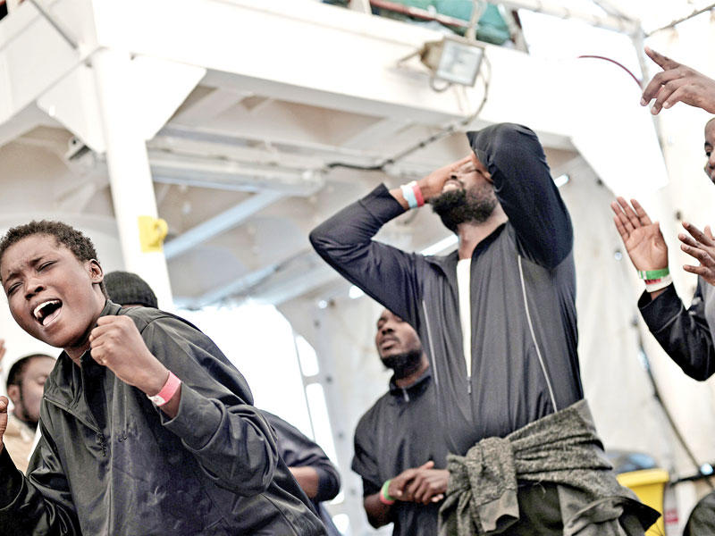 مهاجرون على متن أكواريوس يحتفلون برسو السفينة في إسبانيا أمس (رويترز)