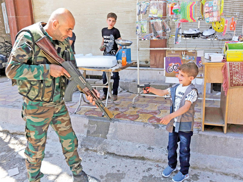 صبي سوري يواجه جندياً بمسدس لعبة في دوما أمس الأول (إي بي إيه)