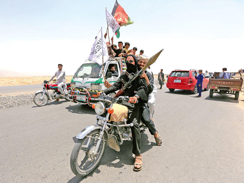 مقاتلون من «طالبان» يرفعون أعلاماً أفغانية ورايات الحركة لدى دخولهم الى إحدى مدن ننغهار شرق أفغاسنتان أمس الأول (رويترز)