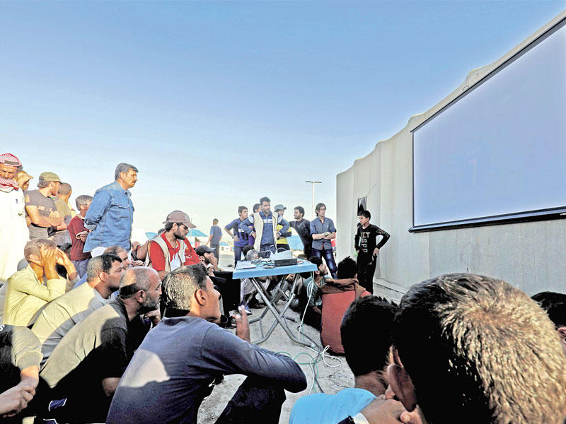 نازحون سوريون يشاهدون مباريات كأس العالم في مخيم عين عيسى بالرقة أمس الأول (أ ف ب)