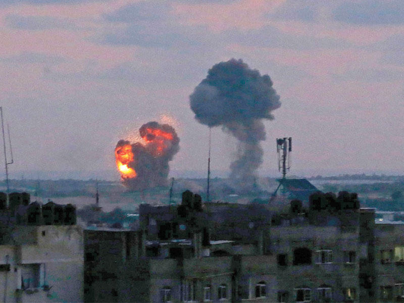 الدخان يتصاعد في سماء غزة فجر أمس بعد قصف إسرائيل ٢٥ هدفاً رداً على صواريخ فلسطينية (أ ف ب) 