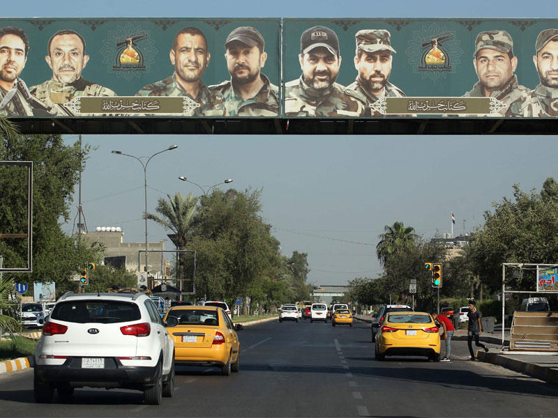 لوحة دعائية لميليشيا حزب الله الموالي لإيران المتدلية على ممر للمشاة فوق شارع فلسطين في وسط العاصمة العراقية بغداد