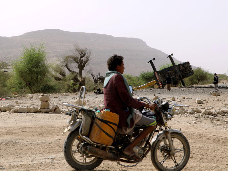 يمني على دراجة نارية يمر قرب شاحنة دمرتها غارة على صعدة أمسt(رويترز)