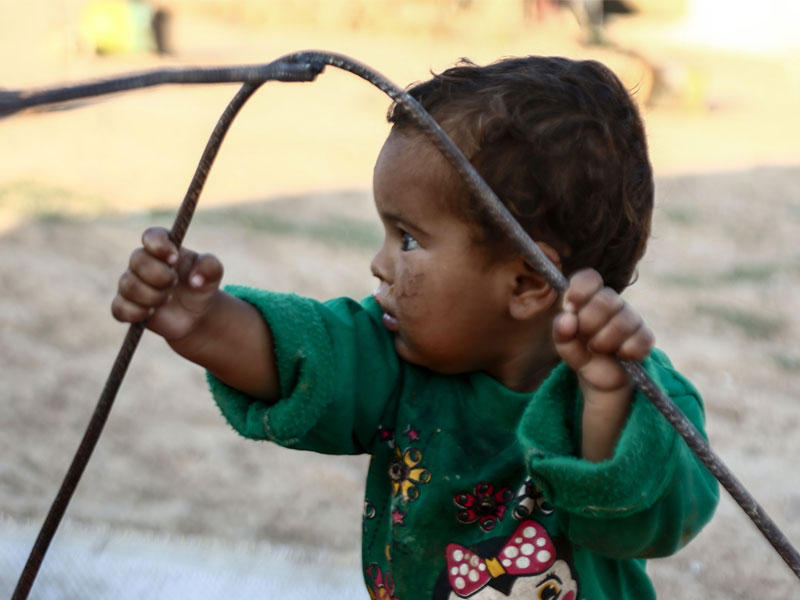 طفل سوري نزح من منبج يلعب خارج مسكنه في مخيم القاضي أمس (أ ف ب)