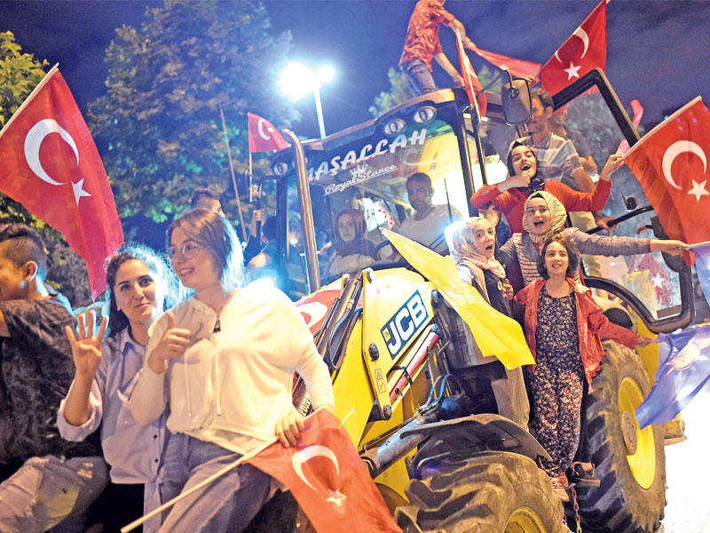 تركيات يحتفلن بفوز إردوغان على حفار أمام مقر حزبه في إسطنبول أمس (أ ف ب) 
