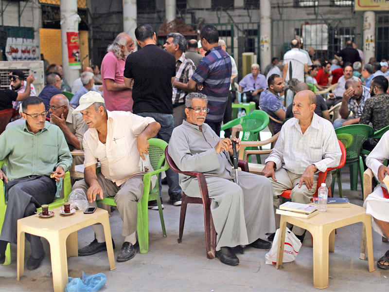 عراقيان في مقهى الشاهبندر بشارع المتنبي وسط بغداد الجمعة الماضية  (رويترز)