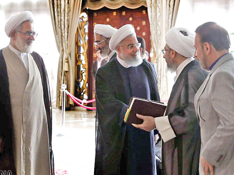 لاريجاني مستقبلا روحاني لدى وصوله لحضور مؤتمر السلطة القضائية في طهران أمس (إرنا)