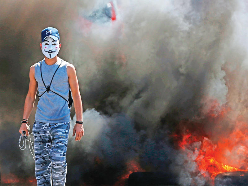 فلسطيني خلال مواجهات مع الاسرائيليين في الضفة أمس (أ ف ب)