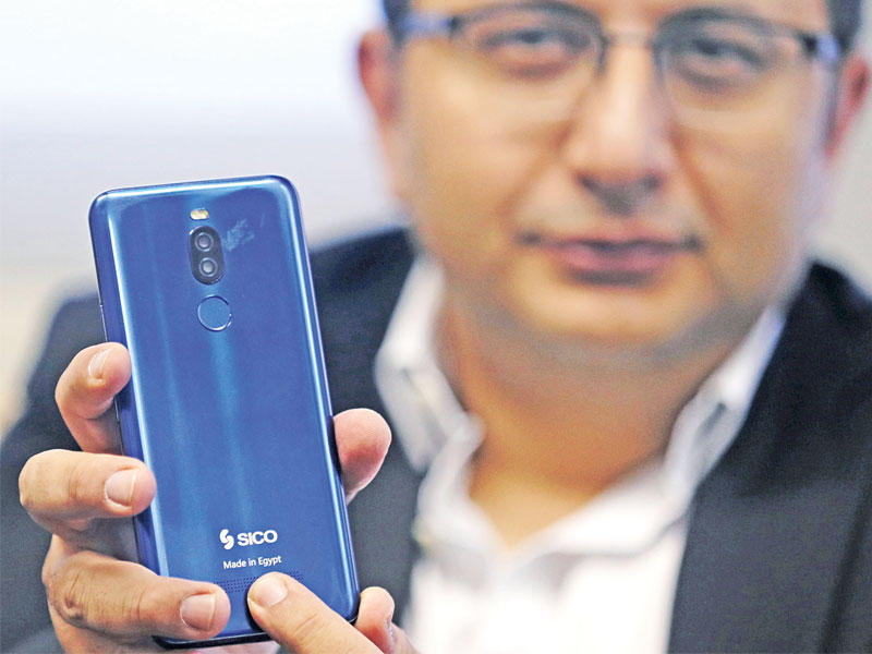مدير شركة «سيكو» ممسكاً بهاتف محمول تم تجميعه بمصر خلال تصريحات السبت الماضي في القاهرة (رويترز)
