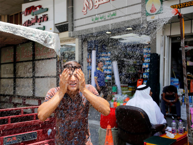 عراقي يحاول التخفيف من حدة الحرارة المرتفعة في بغداد أمس الأول (رويترز)n