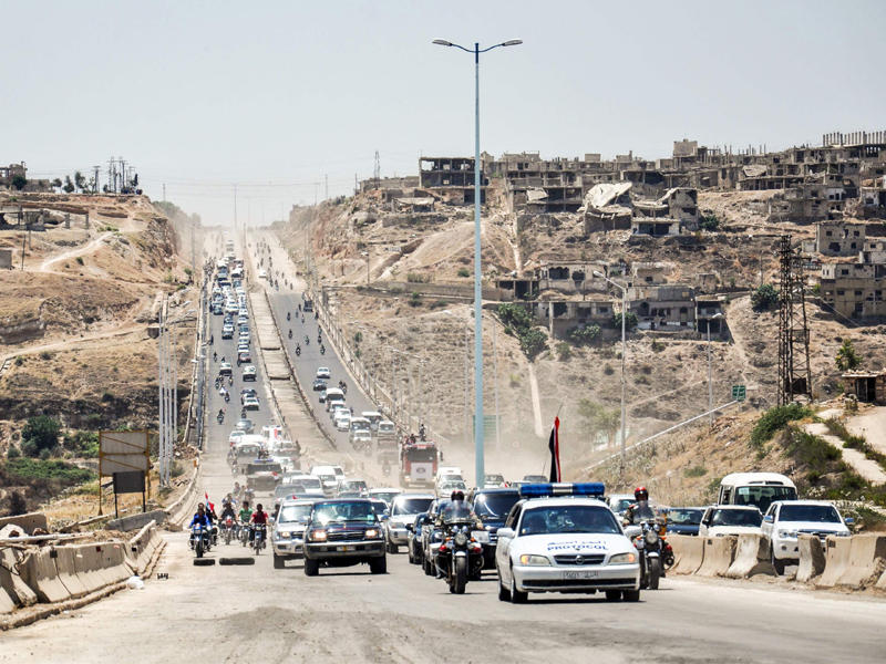 موكب للقوات الموالية للنظام على طريق حماة - حمص (أ ف ب)n