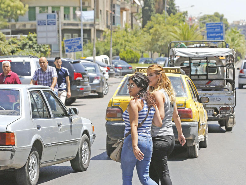 سوريتان تعبران طريقاً في دمشق بعد إزالة الحواجز الأمنية أمس الأول (أ ف ب)n