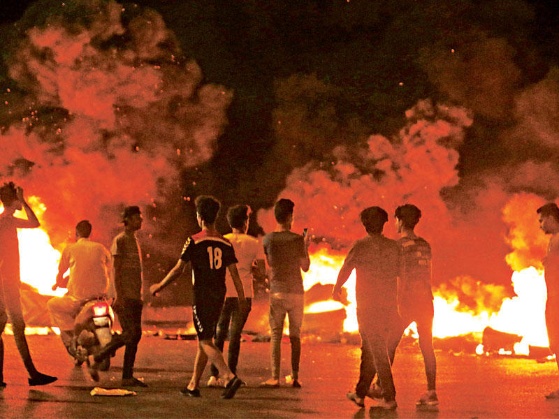 عراقيون يحرقون الإطارات في البصرة أمس الأول (أ ف ب)n