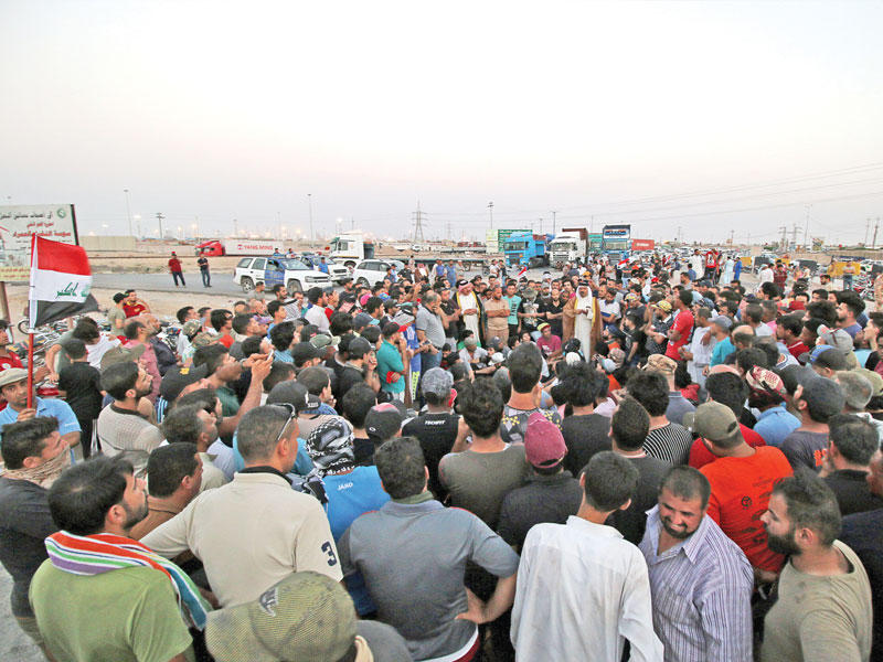 عراقيون يقطعون الطريق إلى ميناء أم قصر بجنوب البصرة أمس الأول (رويترز)