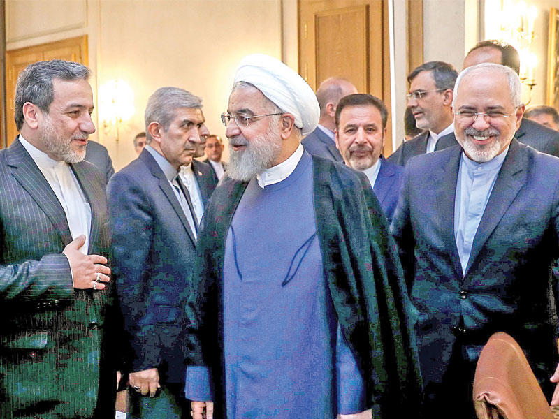 روحاني مستمعاً إلى نائب وزير الخارجية عباس عراقجي لدى مشاركته في اجتماع للدبلوماسيين الإيرانيين بحضور ظريف في طهران أمس  (رويترز)