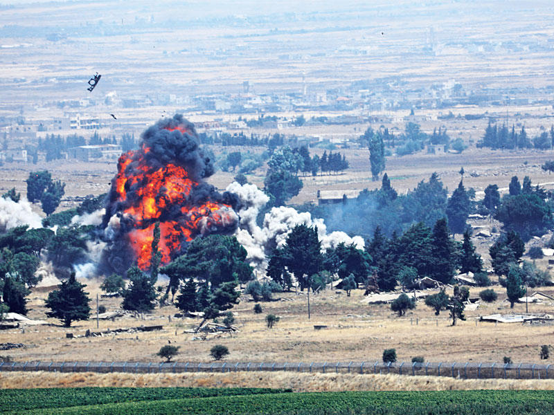 لحظة تفجير «النصرة» لمعبر القنيطرة في صورة التقطت من الجانب الإسرائيلي أمس (رويترز)