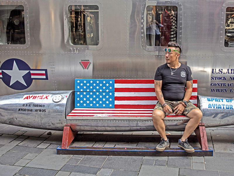 صيني يجلس على مقعد على شكل صاروخ أميركي في بكين أمس (أي بي ايه)