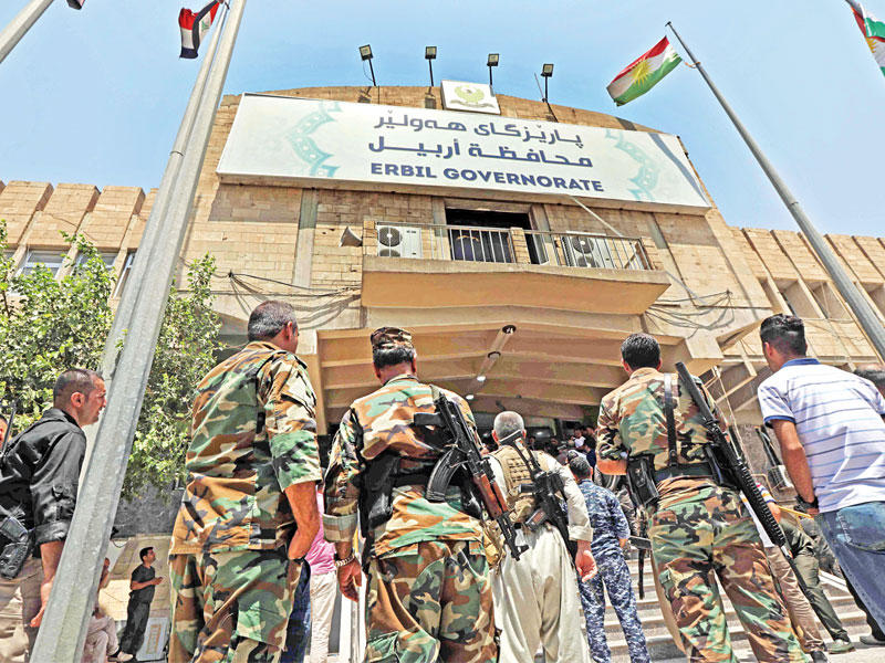 عناصر الأسايش يتجمعون عند مدخل مبنى محافظة أربيل أمس (أ ف ب)