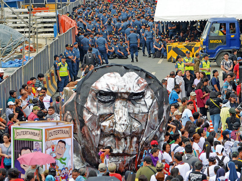 متظاهرون يحملون مجسماً يجسّد الرئيس الفلبيني في مانيلا أمس (أ ف ب)