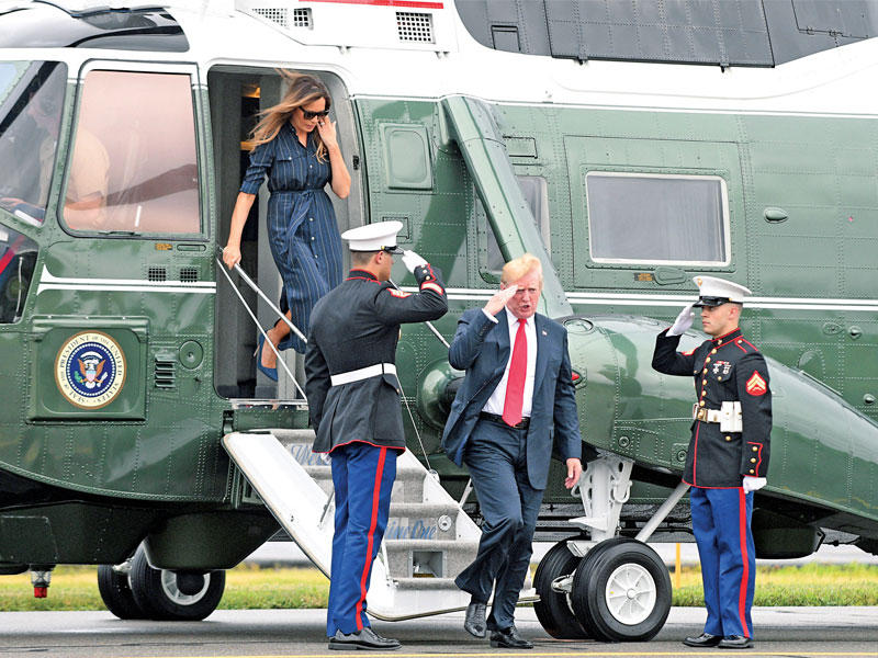  ترامب وزوجته ميلانيا بعد عودتهما بالمروحية الرئاسية من نيوجيرسي (رويترز)