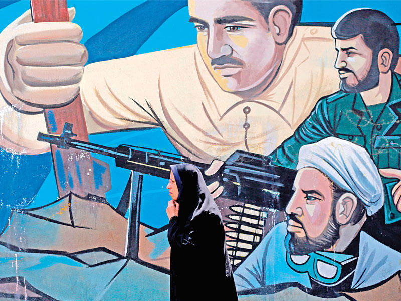 إيرانية تمر أمام جدارية في طهران (أ ف ب)