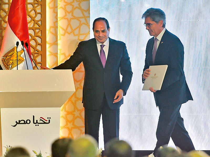 السيسي مرحباً بمدير «سيمنز» خلال حفل افتتاح محطة كهرباءt          (أ ف ب)