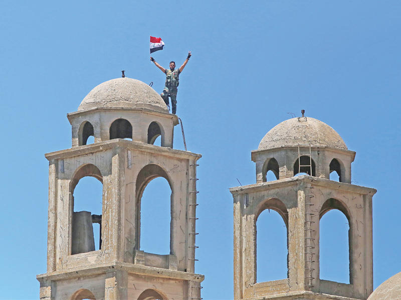 جندي سوري أعلى كنيسة مار جرجس للروم الارثوذكس في القنيطرة أمس الأول (أ ف ب)