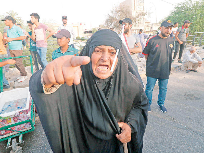 مسنة عراقية خلال تظاهرات في البصرة أمس الأول (أ ف ب)