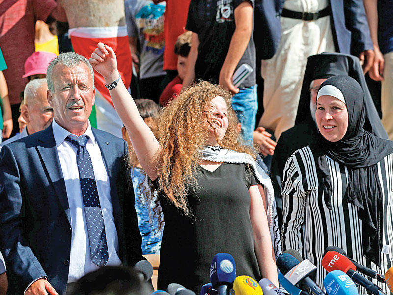 التميمي بين والديها أمس في مؤتمرصحافي عقدته في النبي صالح بلدتها بالضفة (أ ف ب)