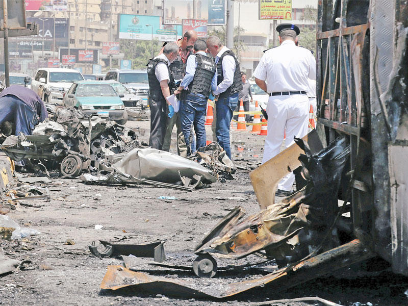 رجال أمن في موقع انفجار السيارة بمحافظة الجيزة أمس    (رويترز)