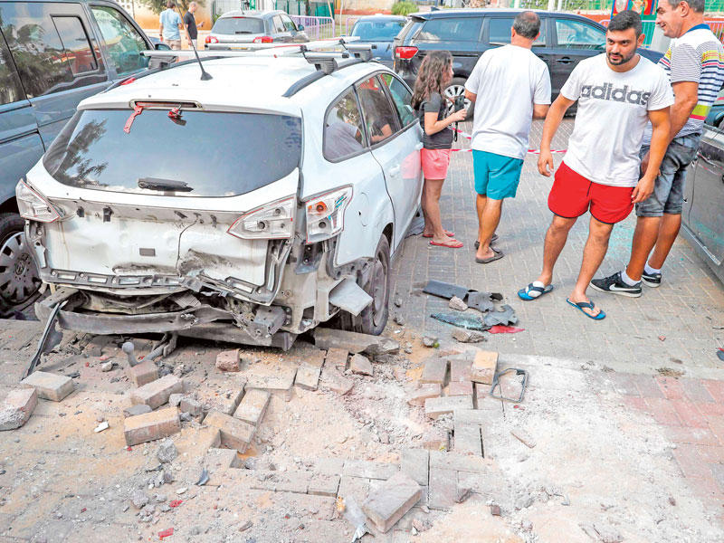 إسرائيليون يتفقدون أمس موقع سقوط صاروخ أطلق من غزة على بلدة سديروت (أ ف ب)