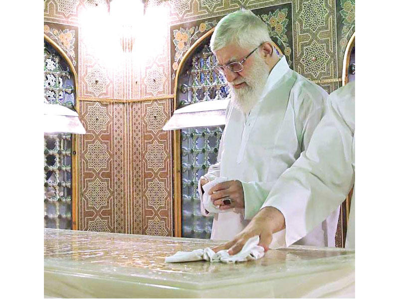 خامنئي ينظف مرقد الإمام علي بن موسى الرضا في خراسان أمس (إرنا)