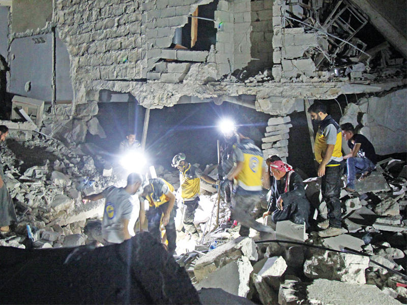 عناصر الخوذ البيضاء يبحثون عن ناجين تحت أنقاض مبنى دمره القصف في أوروم الكبرى بحلب أمس الأول (أ ف ب) 