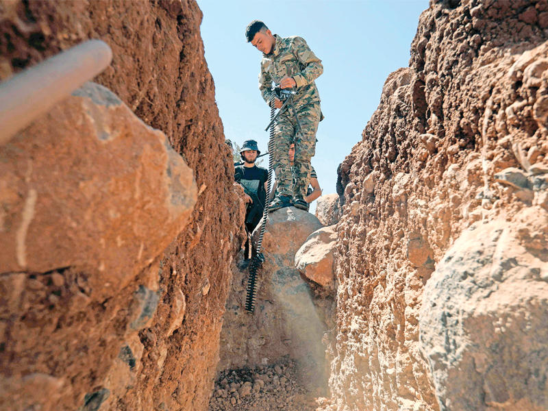 عناصر من كتائب صقور الشام بخنادق في ريف إدلب أمس الأول (أ ف ب)