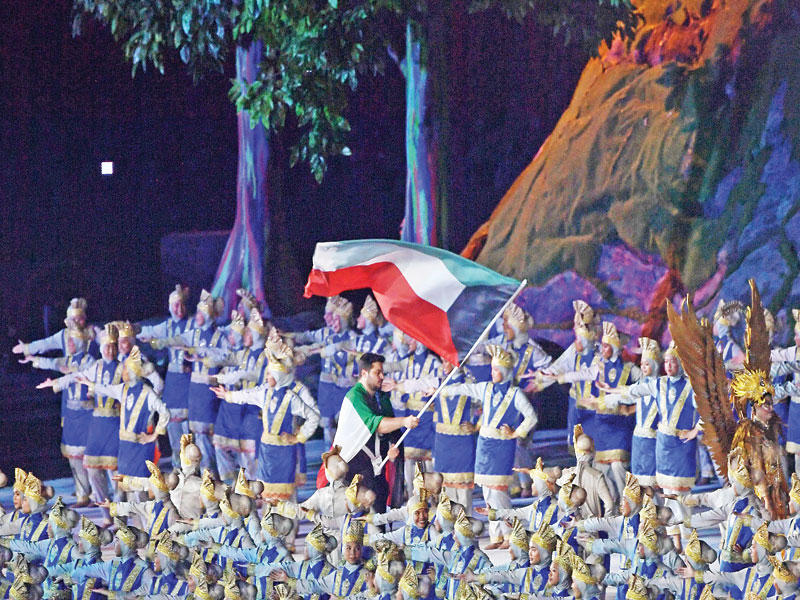 بطل ألعاب القوى عيسى الزنكوي يحمل علم الكويت في طابور عرض الدول المشاركة في «آسياد 2018» أمس  (رويترز)