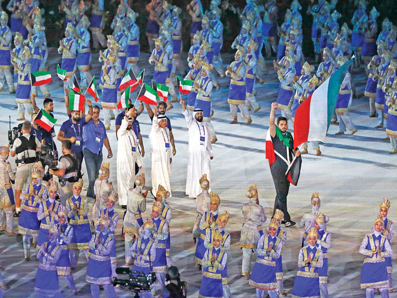 بطل ألعاب القوى عيسى الزنكوي يحمل علم الكويت في طابور عرض الدول المشاركة في «آسياد 2018» أمس t(رويترز)