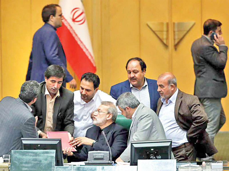 نواب يحيطون بلاريجاني خلال اجتماع بمجلس الشورى في طهران أمس (إرنا)