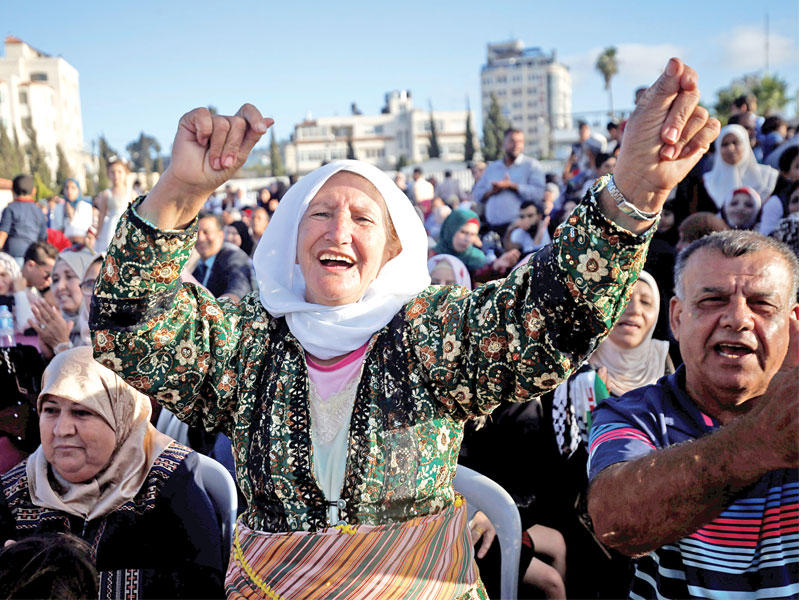   فلسطينية ترقص بعرس 252 شاباً وفتاة في رام الله أمس الأول (رويترز)